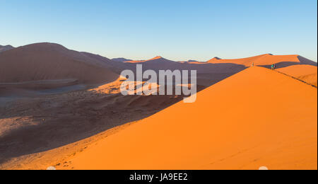 SOUSSUSVLEI, NAMIBIE - 20 juin 2016 : Les gens qui suivent le lever du soleil la forme dune 45 dans la région de Sossusvlei du désert du Namib en Namibie. Banque D'Images