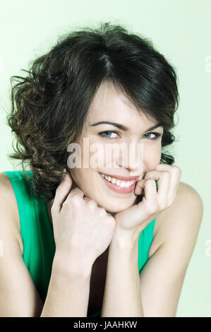 Photos Studio Portrait of a beautiful young young smiling woman sur fond vert Banque D'Images