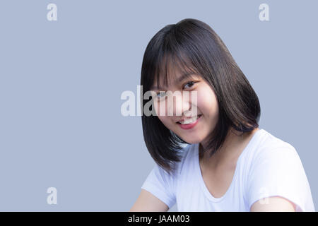 Femme souriante avec peau propre, et des dents blanches sur fond gris portrait Banque D'Images