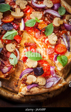 Pizza aux tomates séchées, de salami et de basilic Banque D'Images