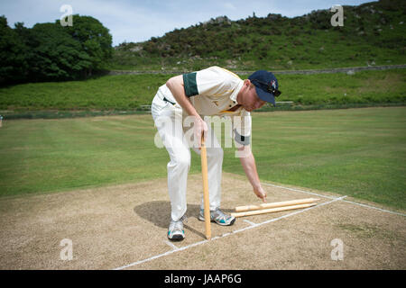 Un joueur fixe les souches avant un match amical entre Cravens Cavaliers et Lynton & Lynmouth Cricket Club à leur base au sol à l'intérieur de la Vallée des Roches, North Devon. Banque D'Images