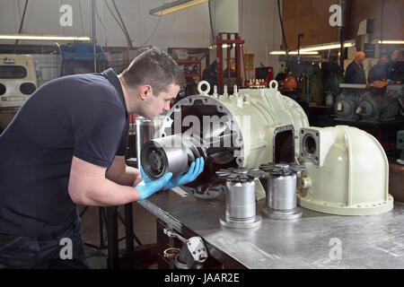 Un ingénieur assemble un compresseur industriel dans une petite usine au Royaume-Uni Banque D'Images