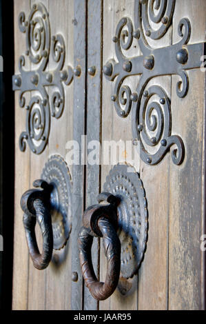 Une vieille porte double en bois avec des influences médiévales et massive doorhandles. Banque D'Images