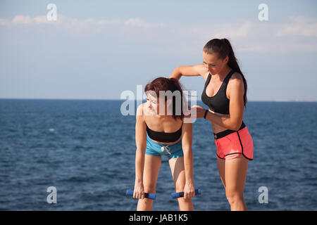 Instructeur de conditionnement physique enseigne une femme de faire du sport Banque D'Images
