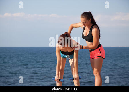 Instructeur de conditionnement physique enseigne une femme de faire du sport Banque D'Images
