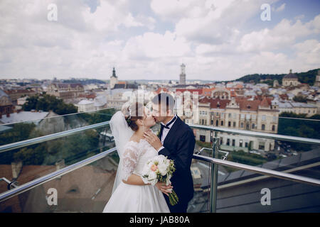 La Mariée Le Marié se tenant à la barrière et le verre dans l'arrière-plan est vu la ville Banque D'Images