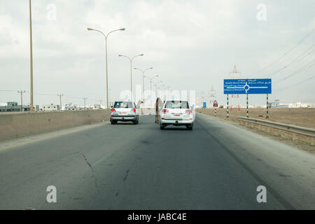 Les chameaux crossing road dans le Gouvernorat de Dhofar, Oman Banque D'Images