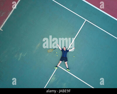 Homme tennis player jeter sur cour avec raquette et balle vue ci-dessus Banque D'Images