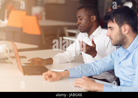 Image de deux jeunes hommes d'interaction at meeting in office Banque D'Images
