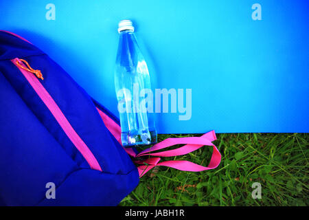 Concept de vie sain. Tapis de fitness, une bouteille d'eau et son sac à dos à partir de ci-dessus. Banque D'Images