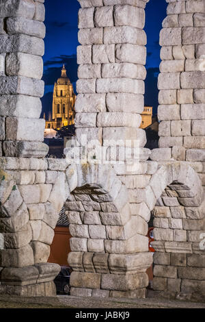 Vue partielle de l'aqueduc romain situé dans la ville de Ségovie la nuit, entre l'une des voûtes de la cathédrale est observé, UNESCO World Heritage Banque D'Images