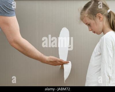 Petite fille gâtée le papier peint et son père est en colère. Banque D'Images