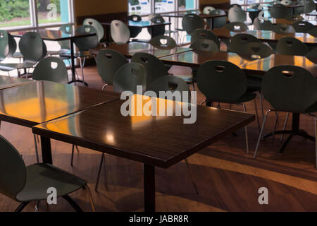 Nettoyer les tables et les chaises de la cafétéria dans une rangée Banque D'Images