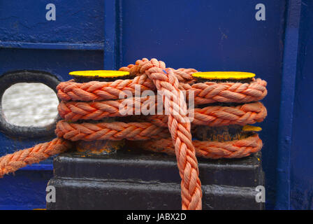 La bobine de corde orange bleu foncé sur fond de peinture. L'équipement du navire. Banque D'Images