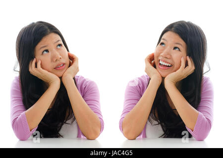 Triste et heureux face expression d'Asian Woman, hands holding face sitting isolé sur fond blanc. Banque D'Images