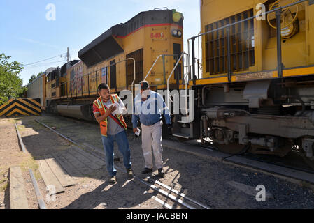 Un train transportant des voitures fabriquées dans les arrêts Nogales, Sonora, Mexique, avant d'entrer dans une barrière métallique à Nogales, Arizona, USA. Banque D'Images