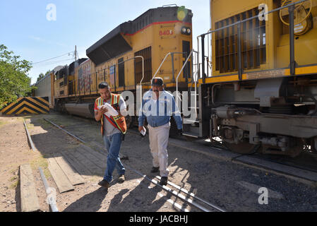 Un train transportant des voitures fabriquées dans les arrêts Nogales, Sonora, Mexique, avant d'entrer dans une barrière métallique à Nogales, Arizona, USA. Banque D'Images