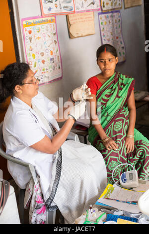 Une femme enceinte reçoit une vaccination de routine dans un centre de santé dans l'Uttar Pradesh, Inde. Banque D'Images