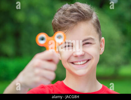 Teen boy with spinner toy in park Banque D'Images