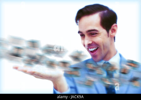 Amusé businessman looking at a picture stream sur fond blanc Banque D'Images