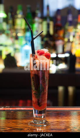 Close up on cocktail coloré avec des fraises sur le bord dans un bar chic Banque D'Images