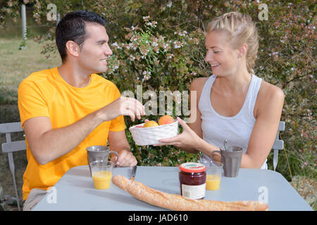 Cute couple having breakfast together outdoors Banque D'Images