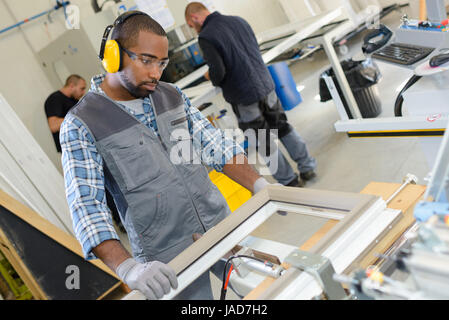 Raccords de travail de l'homme sur une fenêtre Banque D'Images