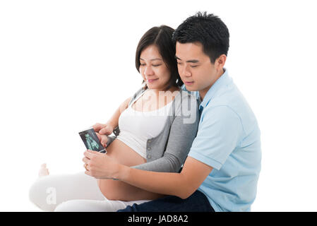 Femme enceinte avec mari holding échographie de l'enfant à naître Banque D'Images