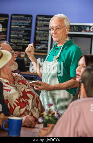 Café barista pointant au menu avec groupe de clients Banque D'Images