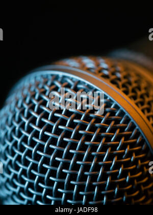 Photo macro d'un microphone vocal en faible lumière allumée avec stage lights. Banque D'Images