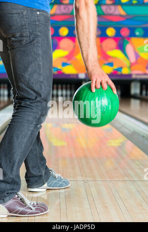 Jeune homme de bowling s'amuser, les lecteurs de l'homme tenant une boule de bowling en face de la ten pin alley Banque D'Images