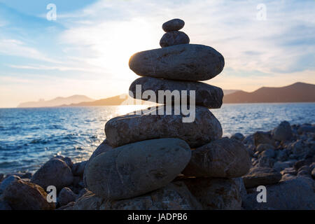 Ibiza Cap des Falco coucher du soleil avec le désir des pierres sur la plage de Sant Josep Îles Baléares Banque D'Images