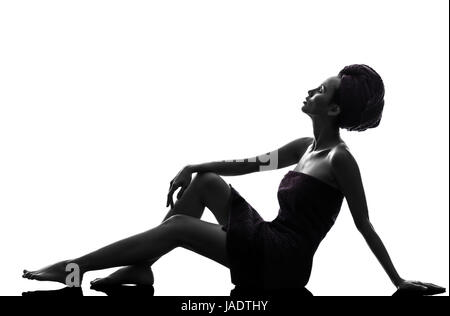 Une belle asiatique jeune femme assise sur le sol jusqu'à la serviette enroulée en silhouette studio isolé sur fond blanc Banque D'Images