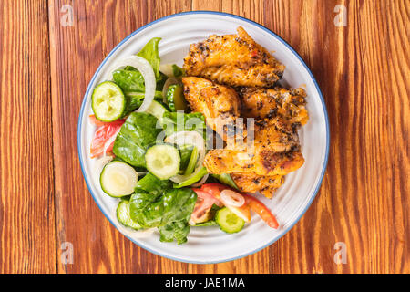 Des ailes de poulet en sauce avec des légumes frais Banque D'Images