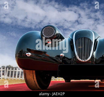 /Low angle view of an unknown old-timer retro vintage sports car sous le bleu ciel nuageux. Le capot avant et le chrome grill de beauté classique looki Banque D'Images