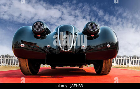 /Low angle view of an unknown old-timer retro vintage sports car sous le bleu ciel nuageux. Le capot avant et le chrome grill de beauté classique looki Banque D'Images