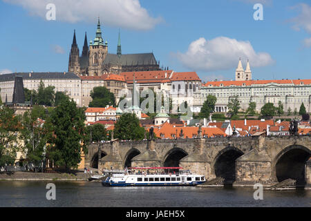 Un bateau passe sous le pont Charles avec le Château de Prague s'élevant au-dessus de l'arrière-plan, Prague, République Tchèque Banque D'Images