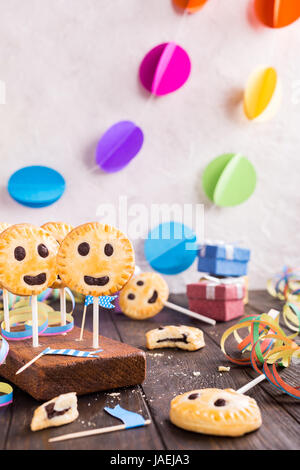 Sablés faits maison smiley cookies au chocolat noir sur stick appelé pie pop. Childrens Party background. Banque D'Images