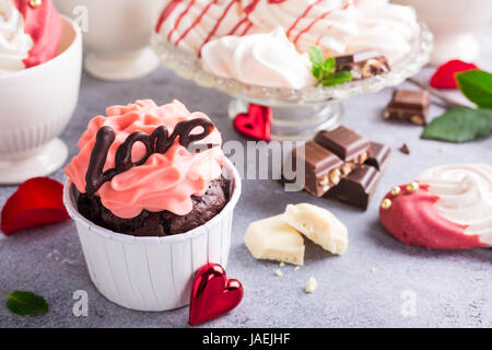 Belle crème rose cupcake, chocolat, meringue cookies et roses rouges sur fond noir en gris. Valentines, jour Mère, mariage concept. Banque D'Images