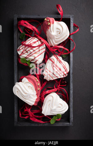 Des meringues en forme de coeur dans la vieille boîte en bois pour la Saint-Valentin, vue du dessus, copiez l'espace. Banque D'Images