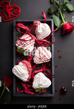 Des meringues en forme de coeur dans la vieille boîte en bois pour la Saint-Valentin, vue du dessus, copiez l'espace. Banque D'Images