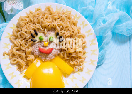 Funny Girl face à la nourriture avec escalope, pâtes nouilles et Légumes Banque D'Images