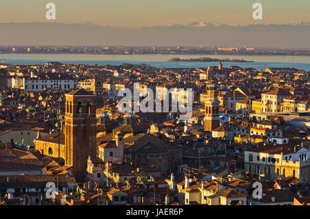 Le téléobjectif vue aérienne de coucher du soleil à Venise du Campanila clocher à Piazza San Marco, Alpes italiennes en arrière-plan, Italie Banque D'Images