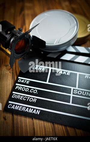 Clapper board avec film lumière et bobines de film sur table en bois Banque D'Images