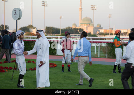 Jockeys et propriétaires de chevaux dans le paddock avant une course au Racing Club à Doha, Qatar. Banque D'Images