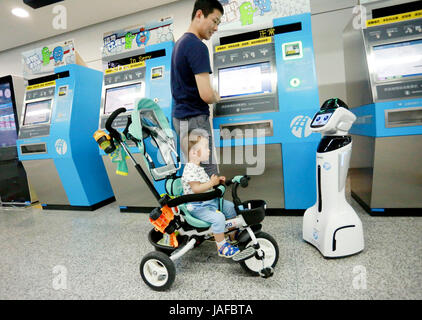 Ningbo, province de Zhejiang en Chine. 7 juin, 2017. Un enfant est attiré par un robot intelligent 'Xiaogui" à la station de métro Parc Yinghua Ligne 1 à Ningbo City, Zhejiang Province de Chine orientale, le 7 juin 2017. Le robot pourrait accueillir les passagers et les aider à obtenir des renseignements tels que prix du billet de train, horaire et l'emplacement des toilettes et des ascenseurs sans obstacle. Credit : Huang Ruipeng/Xinhua/Alamy Live News Banque D'Images