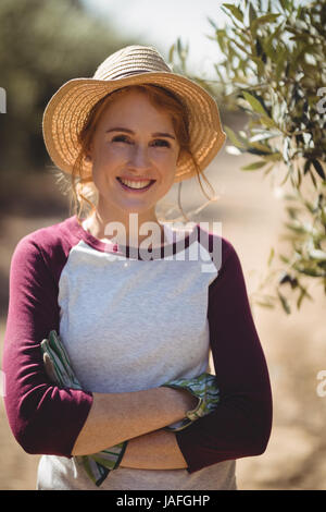 Portrait of smiling young woman with arms crossed standing à l'Olive Farm Banque D'Images