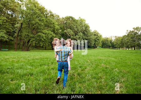 Papa joue avec les enfants dans le parc Banque D'Images