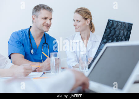 Intéressant le partage de données médicales. Facile à vivre heureux médecins qualifiés bénéficiant d'heures de travail et avoir conversation tout autre collègue en utilisant la Banque D'Images