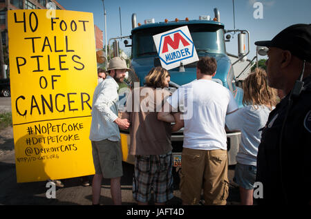 Les partisans et membres de Detroit Coalition contre l'exploitation des sables bitumineux (DCATS) bloquer un transport par camions coke de pétrole à l'installation de stockage à controverse et les quais le long de la rivière Detroit en juin 2012. Avec la police de Detroit et de la Sécurité intérieure par les agents de l'article, le groupe a tenu le chariot pendant près de trois heures avant d'accepter de lui permettre de tourner autour sans dumping sa charge de pet coke. Coke de pétrole a été stocké à découvert le long de la rivière Detroit à partir de 2012, jusqu'à la fin de 2013 lorsque la ville a commandé le pieux toxiques retirés après un tollé général sur les préoccupations environnementales. Banque D'Images